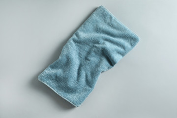 Fresh fluffy towel on grey background, top view