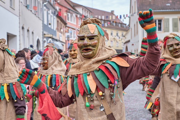 Dancing carnival figure with costume made of sack cloth. Street Carnival in Southern Germany - Black Forest.