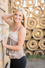 beautiful woman posting in front of a wall of wheels