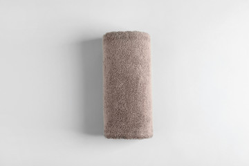 Fresh fluffy rolled towel on grey background, top view