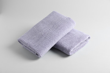 Fresh fluffy folded towels on grey background