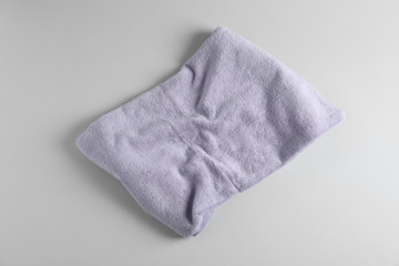 Fresh fluffy towel on grey background, top view