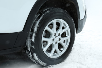 Modern car on snowy winter road, closeup