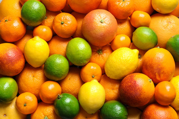 Different citrus fruits as background, top view
