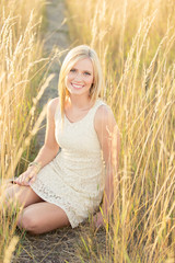 Pretty woman sitting in field smiling