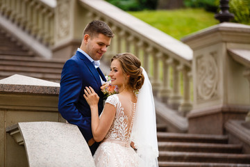 beautiful groom and the bride on a staircase in the palace