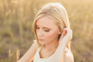 beautiful young girl looking down in field