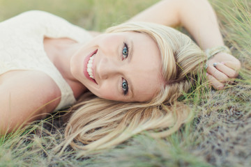 beautiful young girl lying in grass smiling