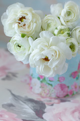 White ranunculus.Beautiful bouquet of spring flowers in a vase on the table. Lovely bunch of flowers.Pastel tonality.