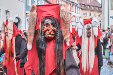 Shrovetide figure with red hood and fox tails. Street Carnival in Southern Germany - Black Forest.