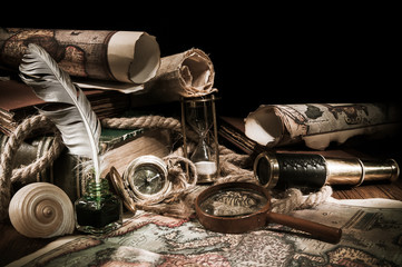 Old maps and vintage objects on a wooden table, high contrast effect effect