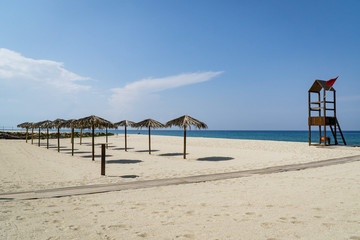 Sonnenschirme und Rettungsturm auf Sandstrand