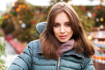 Closeup portrait of a young woman in the winter down jacket