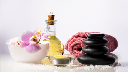 Fototapeta na wymiar Spa set on white background with bottle oil,salt, candle ,orchid, towel and zen spa stones.