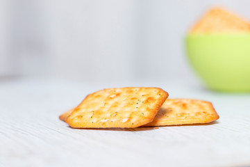 Crispy square cracker in a green plastic bowl