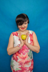 chubby plus size woman holding green apple on blus studio solid background