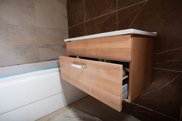 Unfinished Interior of repair and renovation bathroom.  A bathroom remodeling project and design wetroom. Brown marble on the walls. Furniture in protective film.