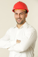 Close up shot of cheerful satisfied attractive male wears a red helmet