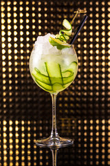 Green fruit cocktail with cucumber in tall round glass