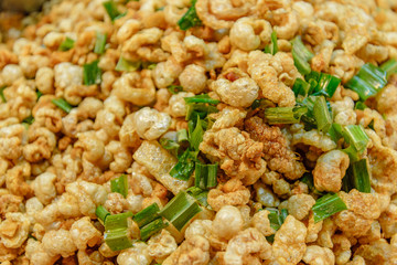 Pile of deep fried or bake pork snack, pork rind, pork scratching or pork crackling on the tray in a market. 