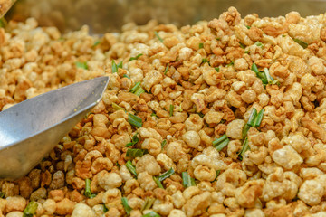 Pile of deep fried or bake pork snack, pork rind, pork scratching or pork crackling on the tray in...