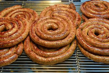 Sai Aua, traditional Northern Thai Spicy Sausage, stack and pile spiral shape of homemade Asian Spicy sausage in market.