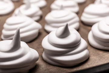 Meringues on backing paper close up