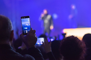many people who dance and record with the phones at the live music concert