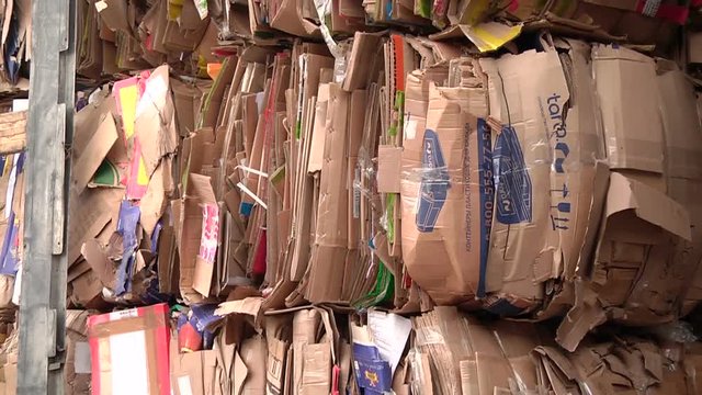The cardboard packaging is compressed and prepared for recycling
