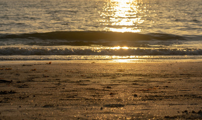 Beach as it runs into the Gulf of Mexico in Florida with sunbeams glowing off the water