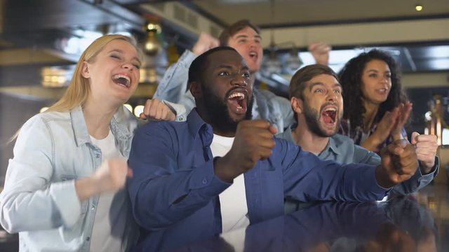 Happy friends watching sports in bar, rejoicing winning game, leisure activity