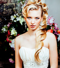 beauty emotional blond bride in luxury interior dreaming, crazy complicate hairstyle, many flowers
