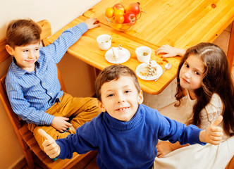 little cute boys eating dessert on wooden kitchen. home interior. smiling adorable friendship...