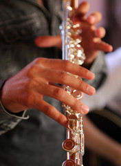 Obraz premium Professional elegant man flutist performing in a white room, hands close up
