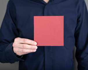 A man holding red note paper
