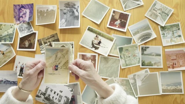 Top view of a senior caucasian woman looking at old photos themes of memories nostalgia photos retired