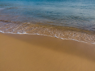 Small waves in an empty beach shore.