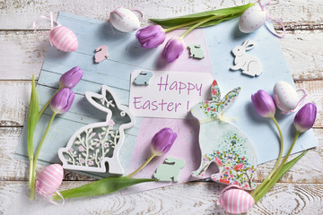 pastel color easter flat lay with tulips  bunnies and greeting text
