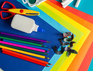 Stationery for study at school lies on blue. Back to school. Rainbow color