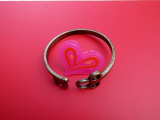 Skeleton key cuff bent around pink heart on pink background