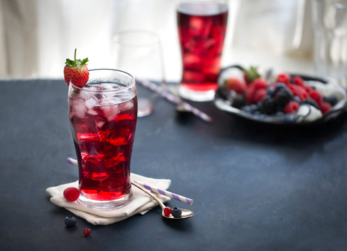 Iced mix berry juice on dark blue table top. Horizontal view text space image.