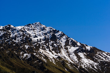 mountain peak covered by snow, sunny day with cloudless blue sky