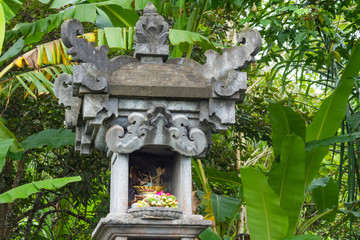 Little Hindu temple with offerings in garden