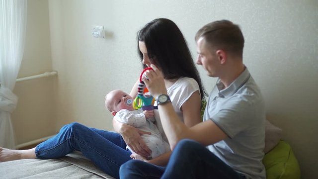 Man and Woman Talking and Playing with Baby