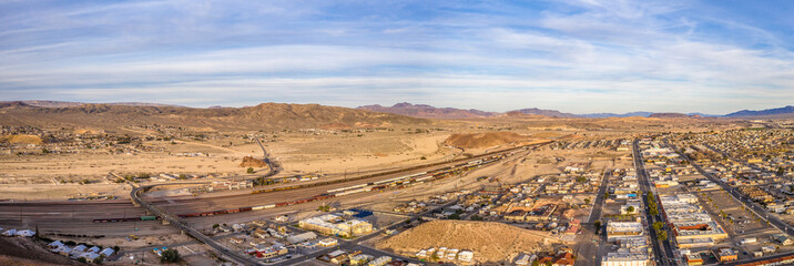 Naklejka premium Aerial view of Barstow community a residential city of homes and commercial property community Mojave desert California USA at sunset. Railway Station and Museum