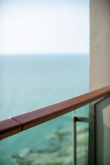 Fototapeta na wymiar Wooden designed handrail in a balcony of a luxury hotel during a sun set scene.