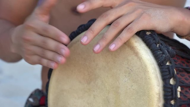 Man musician playing on a Bongo drum close up. Hand tapping a Bongo drum. Drummer hands, movement, rhythm. Koh Phangan island, Thailand