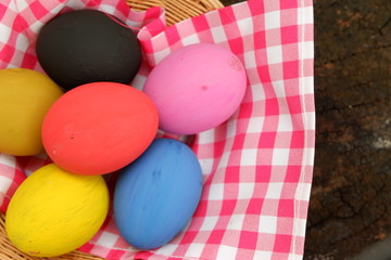 Fototapeta na wymiar Easter eggs in basket on wooden background