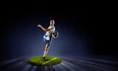 Soccer player on round pedestal. Mixed media