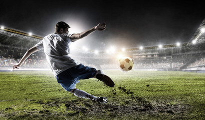 Obraz na płótnie Canvas Soccer player at stadium. Mixed media